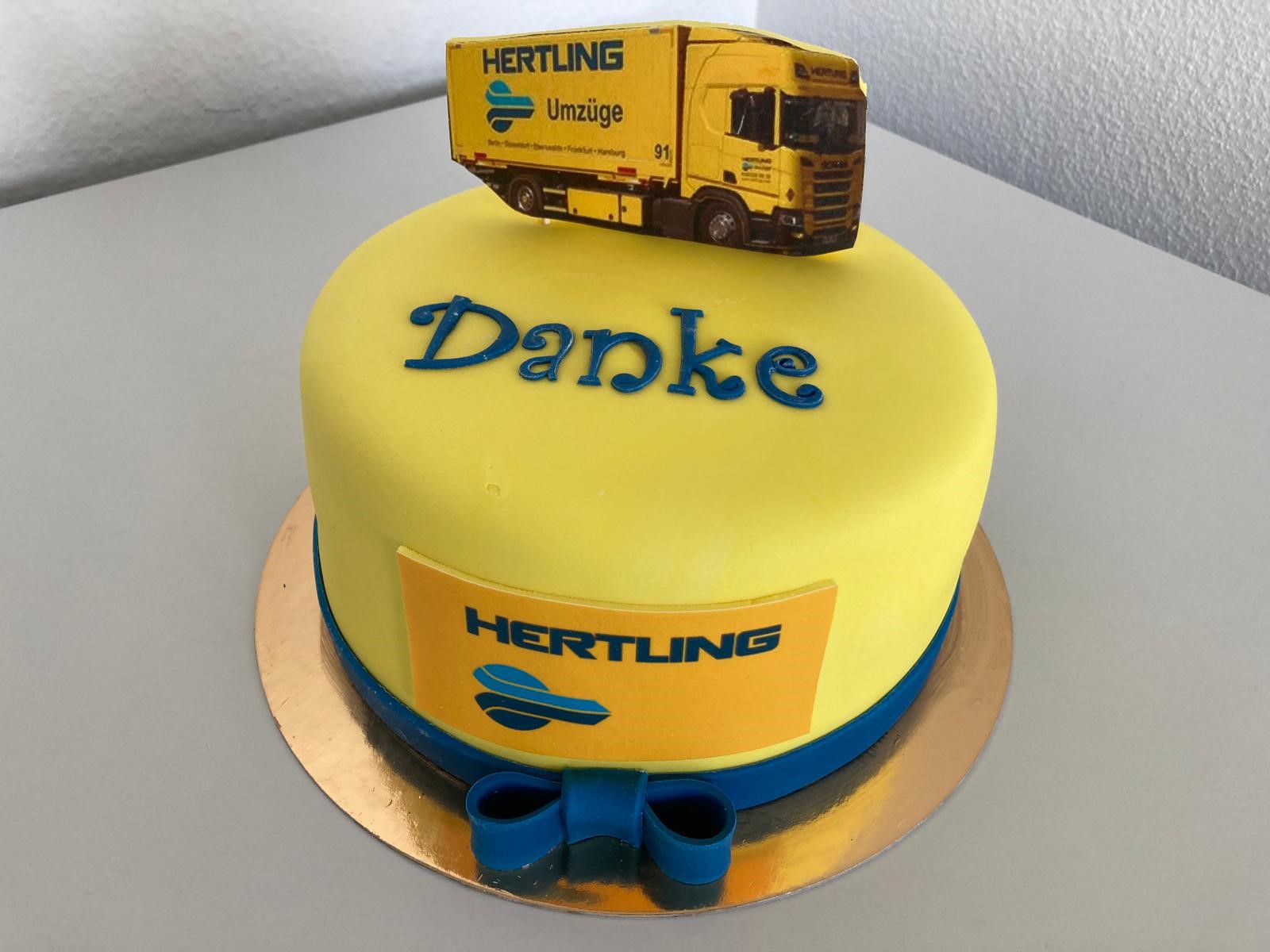 Gelber Geburtstagskuchen mit HERTLING Logo und einem HERTLING LKW