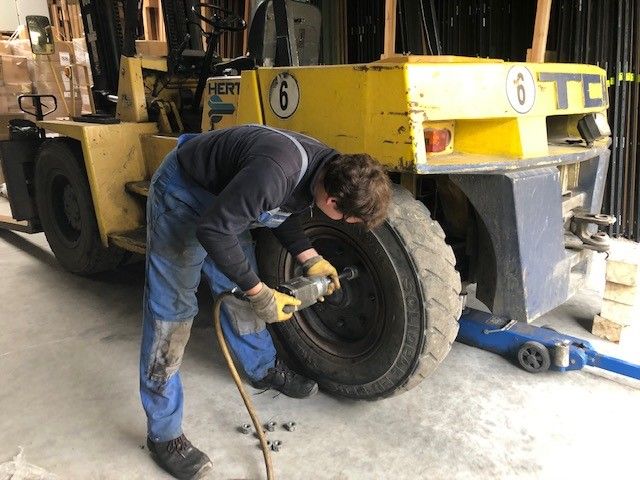 Forklift truck dismantling old tires
