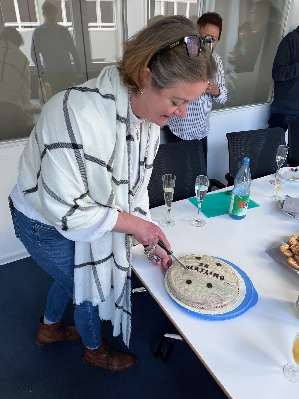 Ms. Schorn while cutting the anniversary cake