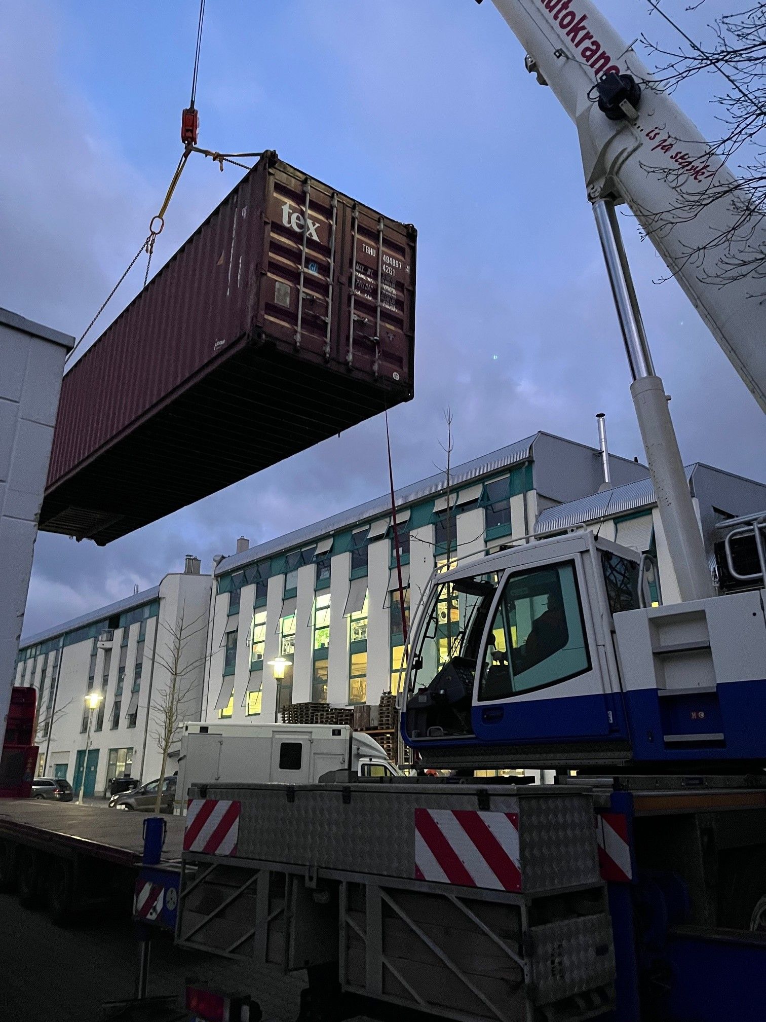 Mobile crane lifting 40 foot storage container